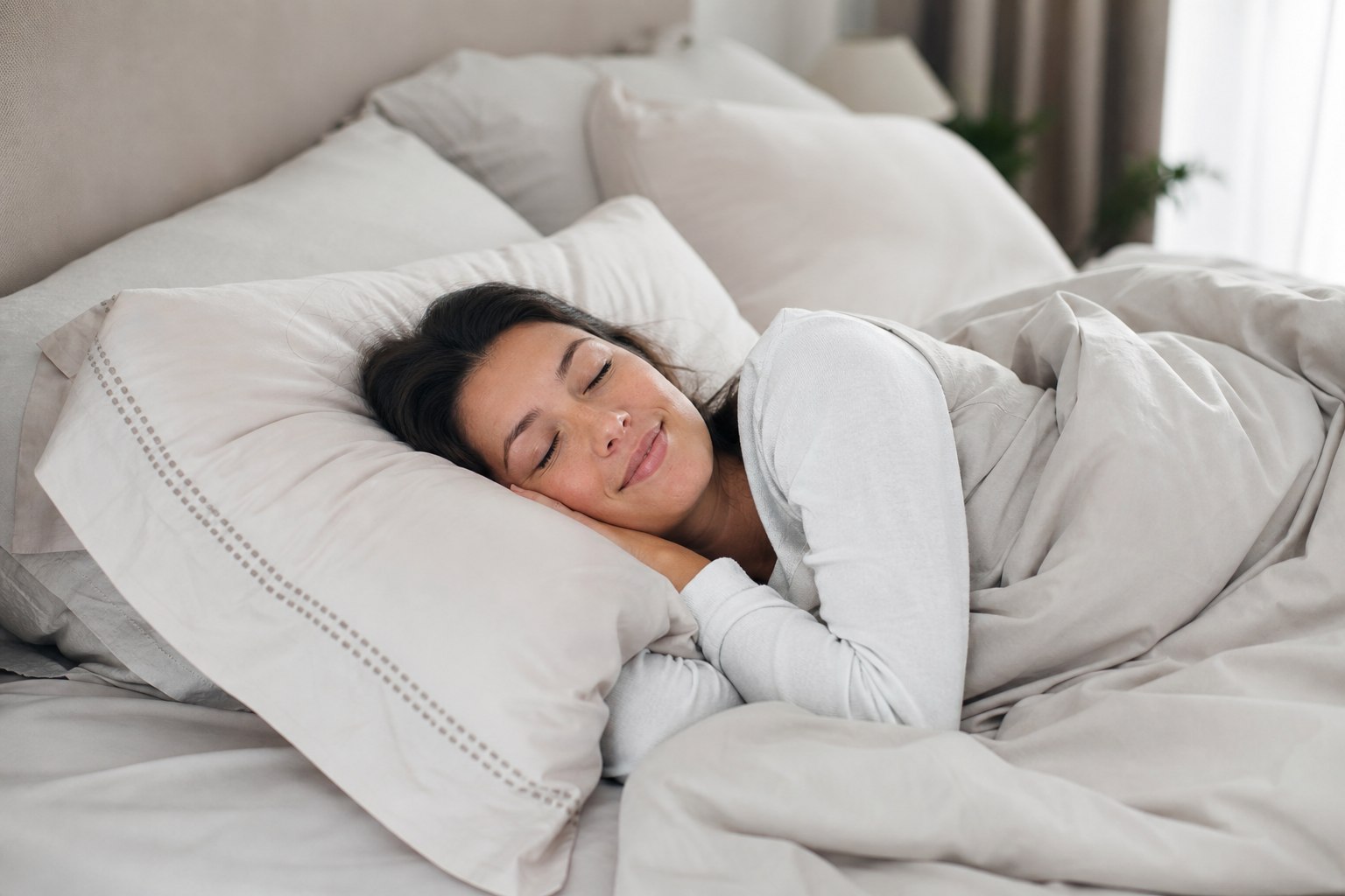 O persoană relaxată în pat, ilustrând importanța unui mediu de somn perfect